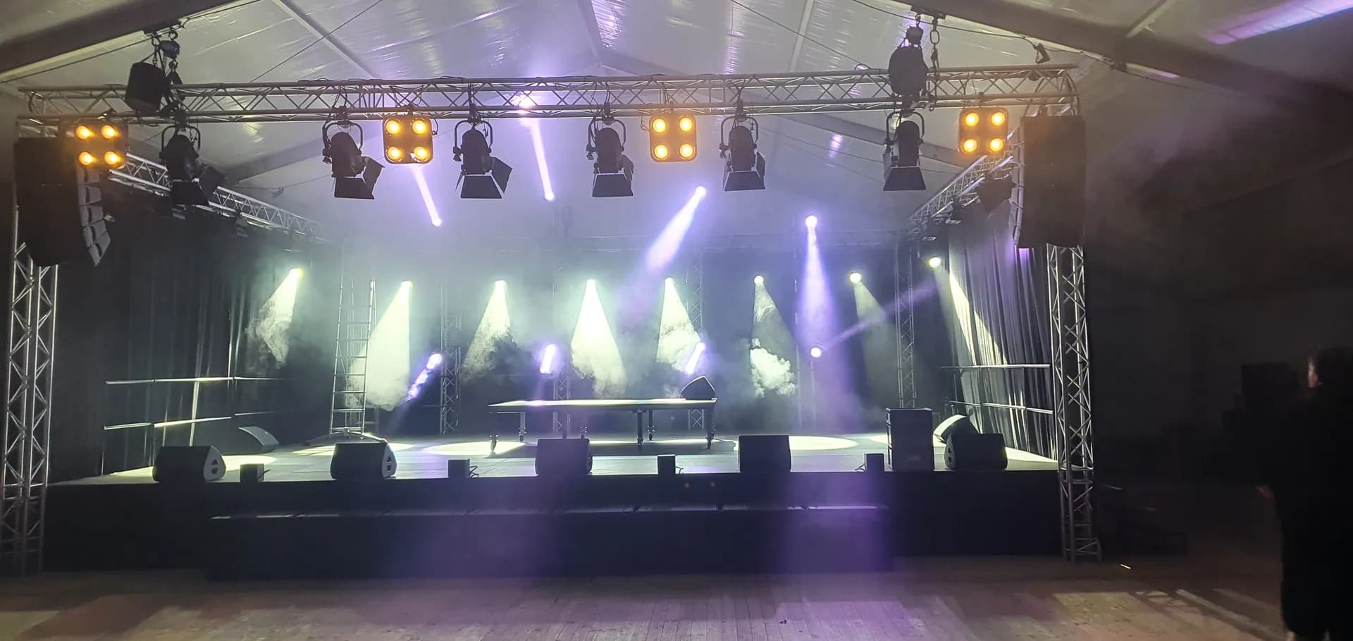Fertig aufgebaute Bühne vor dem Event: Traversendach mit Scheinwerfern, Line-Array und Monitoren im Festzelt