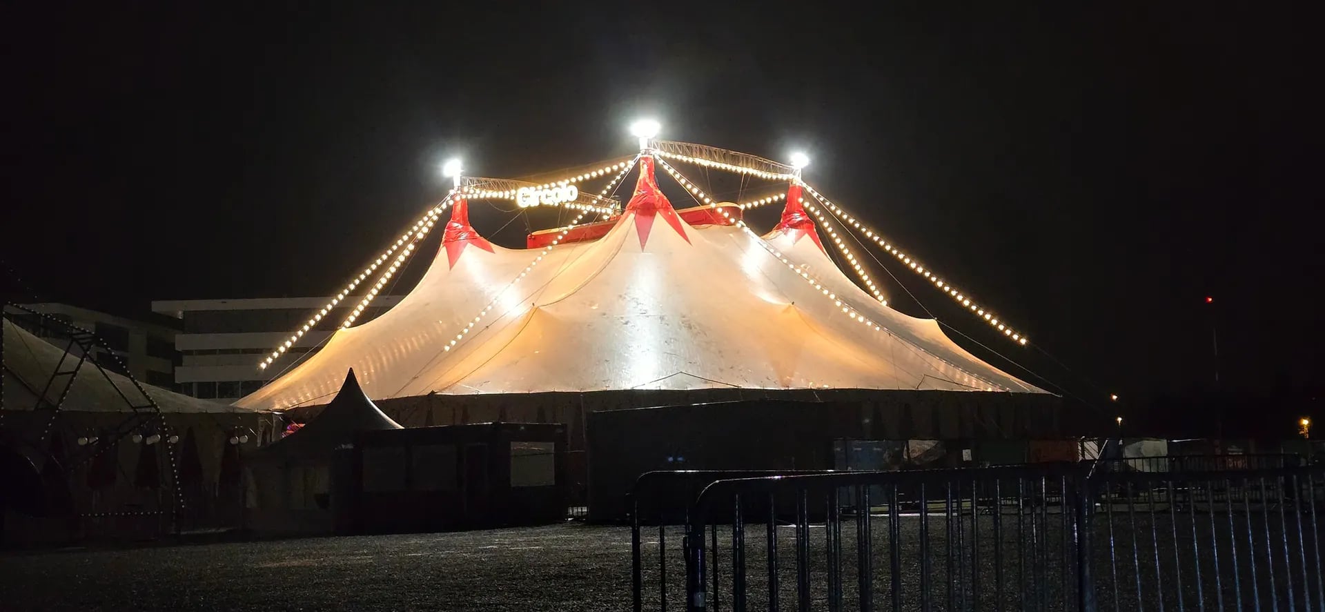 Beleuchtetes Veranstaltungszelt bei Nacht von außen